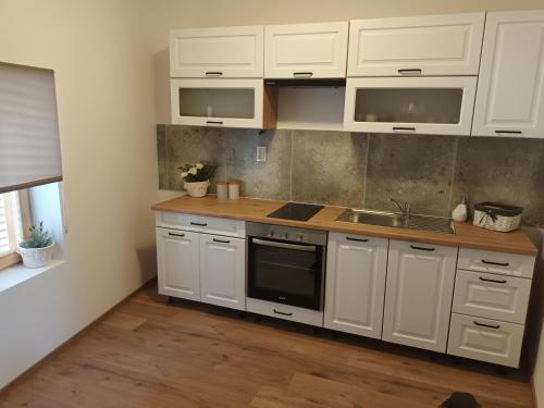 比奥格勒·纳·莫鲁Apartman Kala的厨房配有白色橱柜和水槽