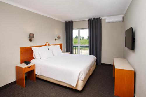 埃斯特雷莫斯Estremoz Hotel的一间设有大床和窗户的酒店客房