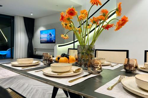 后川PLAYA Villa in Sanctuary Resort - 100m from Private Beach - New 2023的一张餐桌,上面有花瓶