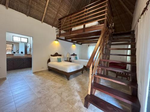 女人岛Na Balam Hotel的一间卧室设有楼梯,卧室内设有一张床