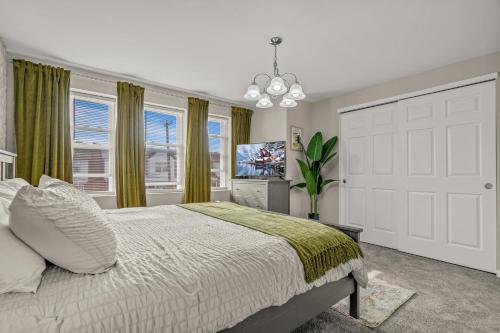 费城Uptown Gem! 2Luxe King Suites - 5 Smart TV's - Parking的一间卧室设有一张床、一台电视和窗户。