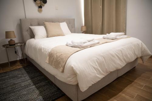 尼科西亚Glamorous, Renovated 3-Bedroom Apt in Nicosia的卧室配有带毛巾的大型白色床