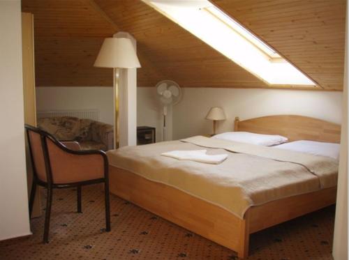斯塔拉·里斯拉奥特多夫佩希恩酒店的一间卧室配有一张大床和一把椅子