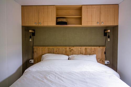 圣安娜兰Het Hoefje的一张带木制床头板和橱柜的床