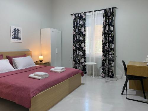 爱琴娜岛Nasos Aegina Apartment的一间卧室配有一张床、一张书桌和一个窗户。
