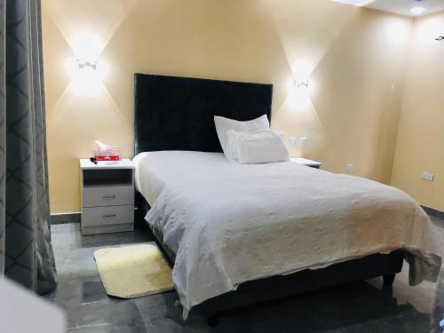 卢萨卡Batoka Apartments的一间卧室配有一张大床和黑色床头板