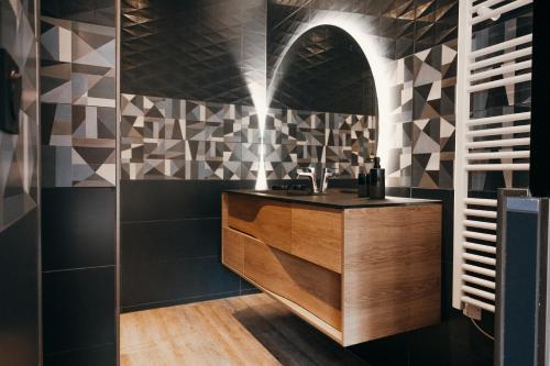 拉特斯特德布赫LA MAISON CACHEE-BA的浴室铺有黑白瓷砖,设有水槽