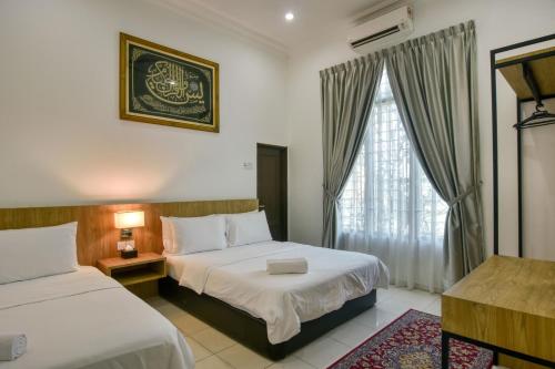 马六甲Elshape Holiday HOME的酒店客房设有两张床和窗户。