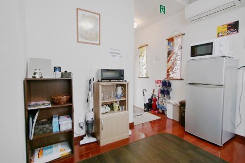冈山冈山熊猫度假屋的客房设有冰箱和带冰箱的架子。