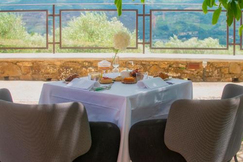 蓬塔谢韦Podere Belvedere Tuscany的一张带食物的白色桌子和椅子