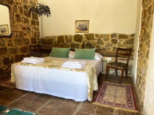 蓬塔谢韦Podere Belvedere Tuscany的一间卧室设有一张床和石墙