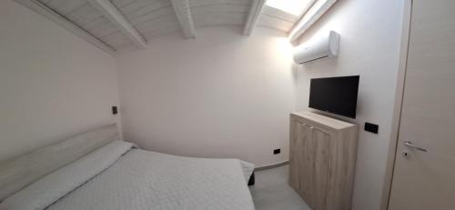 锡拉库扎Luxury home 2的一间白色的小卧室,配有一张床和一台电视