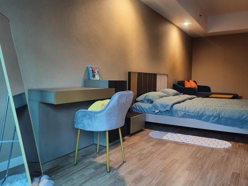 曼谷Baan Nonzee Condo的一间卧室配有一张床和一张蓝色椅子