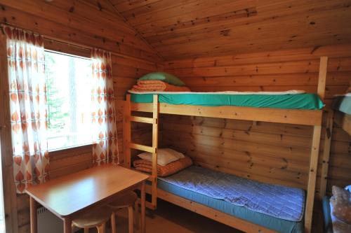 维塔萨里汉尼兰萨米露营地的小屋设有两张双层床和一张桌子