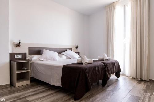 麦德林Mesón Hostal La Cabaña的白色卧室配有带2条毛巾的床