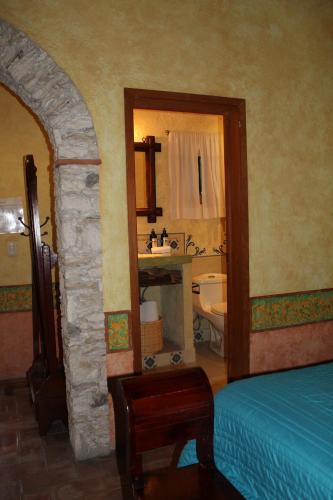 贝纳尔Hotel Casa Caro的一间卧室,配有带水槽和卫生间的浴室