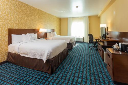 贝城Fairfield Inn & Suites by Marriott Bay City, Texas的酒店客房配有两张床和一张书桌