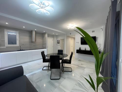 贝纳尔马德纳Luxury apartment Benalmadena First line的厨房以及带桌椅的起居室。