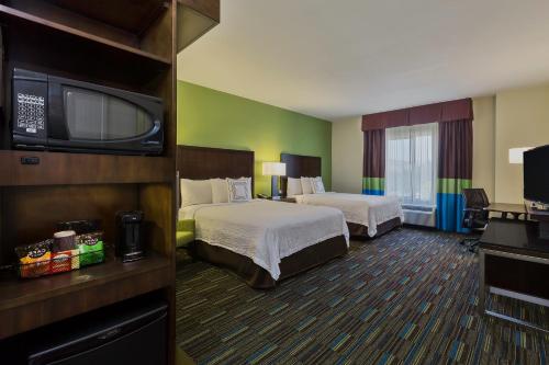 诺科科罗娜河畔/诺尔科费尔菲尔德套房酒店的酒店客房设有两张床和一台平面电视。