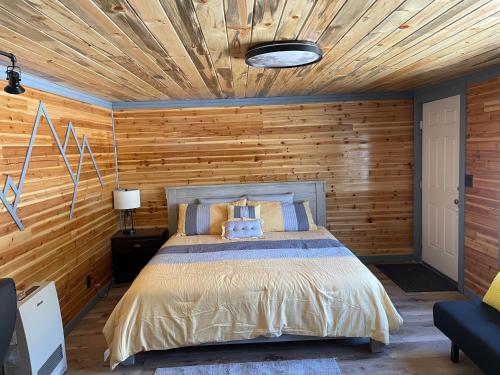 BakerThe Whispering Elms Motel的一间卧室配有一张木墙床
