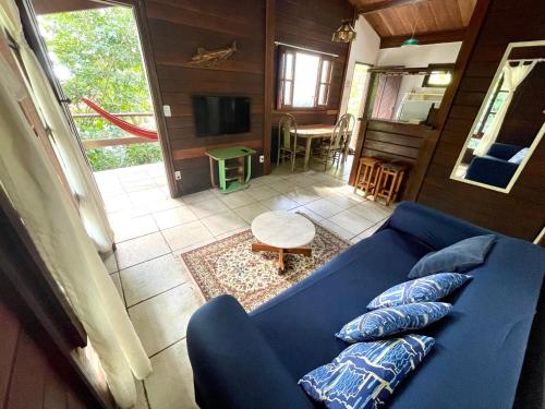 阿布拉奥Casa Selva - Vila do Abraão - Ilha grande的客厅配有蓝色的沙发和电视