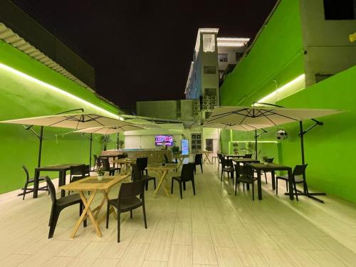 拉利伯塔德Libertad 109 Hotel的餐厅设有桌椅和绿色的墙壁