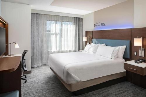 兀兰EVEN Hotels - Shenandoah - The Woodlands, an IHG Hotel的酒店客房设有一张大床和一张书桌。