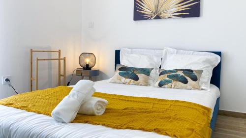 贝济耶Élégant Studio Climatisé 'Alma 2' - Cœur de Beziers - Wifi Fibre - Netflix的一张带黄色毯子和枕头的床