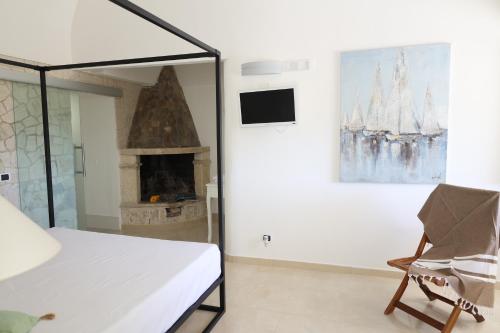 维耶斯泰Tenuta Valle Della Corte的一间卧室设有壁炉、一张床和一把椅子