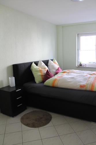韦茨拉尔Gemütliches Apartment, nahe Wetzlar的卧室里配有带枕头的黑色沙发