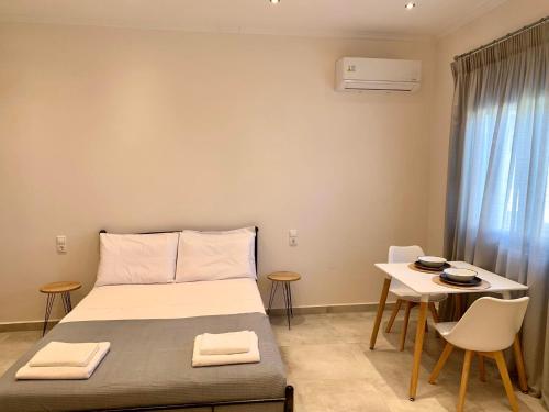 利吉亚Lýria Boutique Apartments的卧室配有一张床和一张桌子及椅子