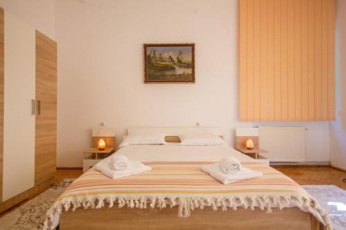 布拉索夫Barok Apartments的一间卧室配有一张大床和毛巾