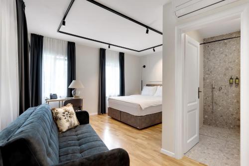 卢布尔雅那Bloom Hotel的一间卧室配有一张床和一个沙发