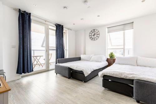 伦敦Stylish & Comfortable Top-Floor Flat in Harrow的一间卧室设有两张床和大窗户