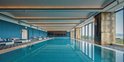 杭州杭州滨奥皇冠假日酒店的一个带蓝色墙壁和窗户的游泳池