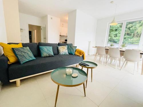 卢森堡Luxury Green Penthouse Terrace&Parking - 117的客厅配有蓝色的沙发和桌子