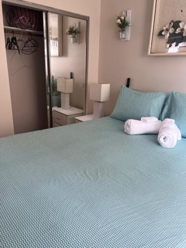 布鲁克林Cozy & Relax LLC Airb&b的一间卧室配有绿床和毛巾