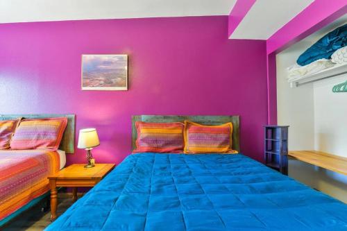 摩押Cozy Adventure Pad Near Downtown - Rose Tree 2的一间设有两张床和紫色墙壁的客房
