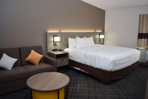 东叙拉古Comfort Inn & Suites Syracuse-Carrier Circle的酒店客房,配有床和沙发