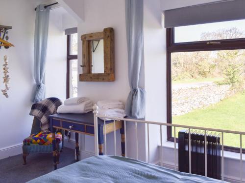 LlandwrogTy Newydd的一间卧室配有一张床、镜子和窗户