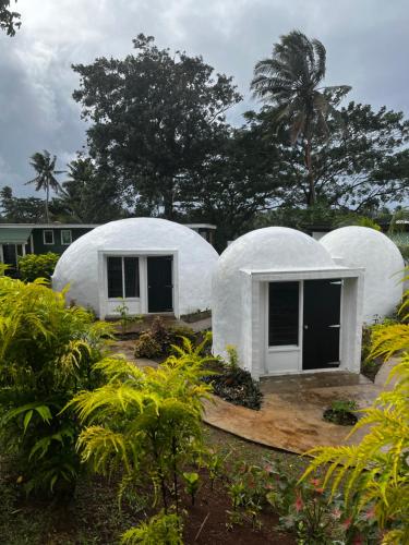 马太Camp Taveuni的两栋石器时代的石器时代房屋 - 花园内树木环绕