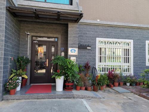 金宁乡绅士民宿的一座种植盆栽植物的建筑的前门