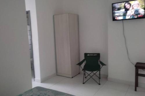 Villa ElisaDepartamento en Villa Elisa.的一张绿色椅子,坐在墙上的房间