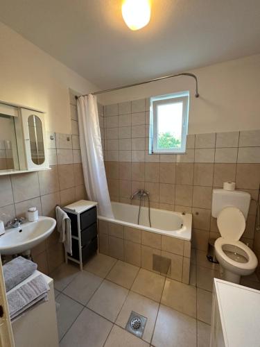 扎达尔Relax and Unwind: Family-Friendly House near Zadar in Zagrad的带浴缸、卫生间和盥洗盆的浴室