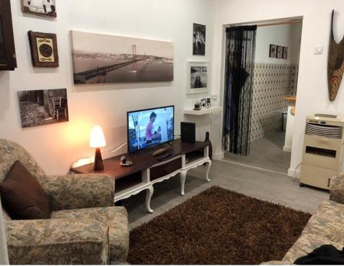 奥迪韦拉什Grandma`s house in Lisbon的一间客厅,配有一张桌子上放的电视