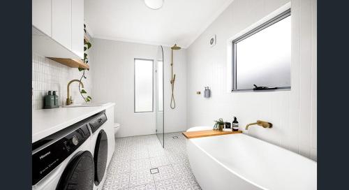 悉尼The South bay's home-Big RoomA的带浴缸和洗衣机的白色浴室