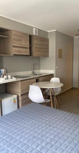 特木科Apart Center Temuco的厨房配有桌椅和水槽。