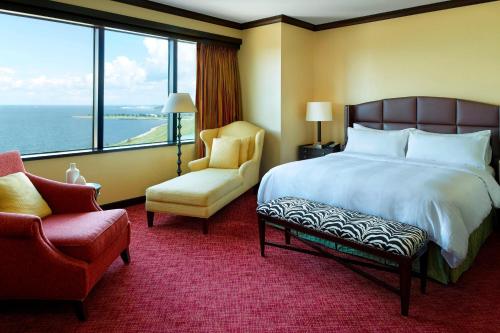 梅泰里新奥尔良梅泰里莱克威万豪酒店的酒店的客房 - 带一张床、椅子和窗户