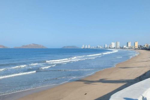 马萨特兰Casa Familiar Olímpica Para 8 - 10 Personas - 5 Min Malecón y Playas的海滩与大海,建筑背景