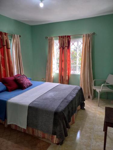 Spanish TownSevelle Meadows 2 Extended Stay的一间设有床铺的卧室,位于一个拥有绿色墙壁的房间